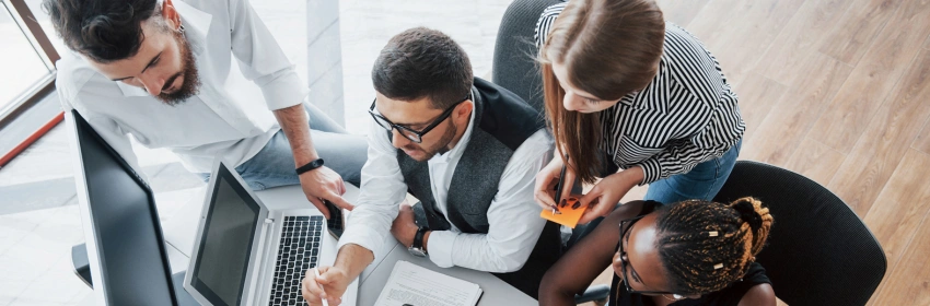 grupo-de-pessoas-multinacionais-ocupadas-trabalhando-no-escritorio-olhando-o-computador-e-o-celular